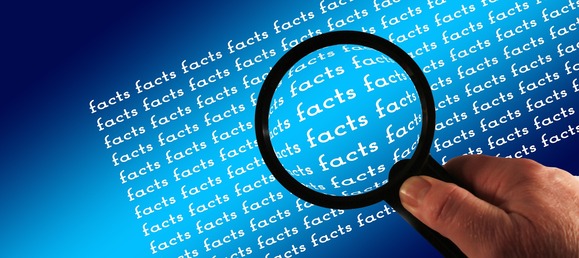 Lupe über blauem Hintergrund, die das Wort „facts“ mehrfach vergrößert darstellt.